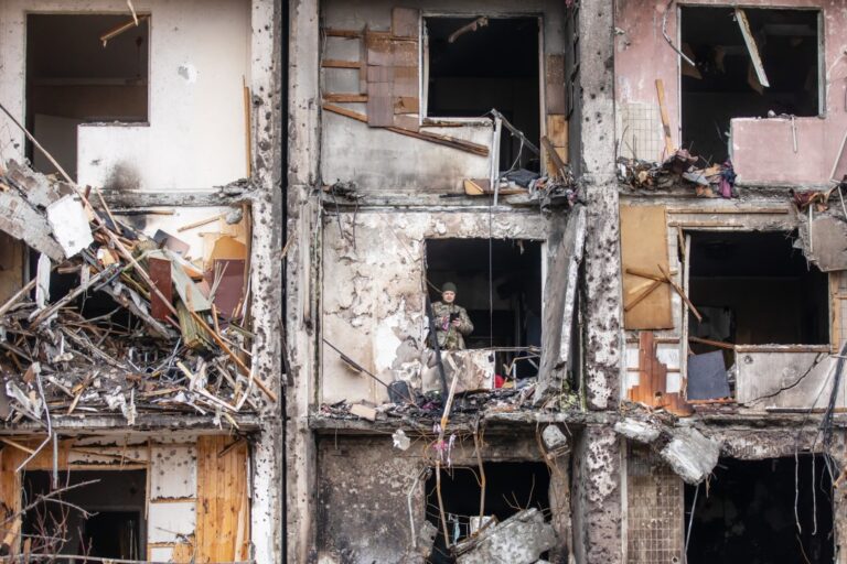 Man searching through bombed-out apartment building in Kyiv