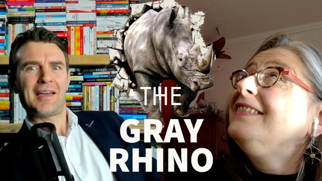 Aidan McCullen and Michele Wucker look up at a gray rhino charging through the screen