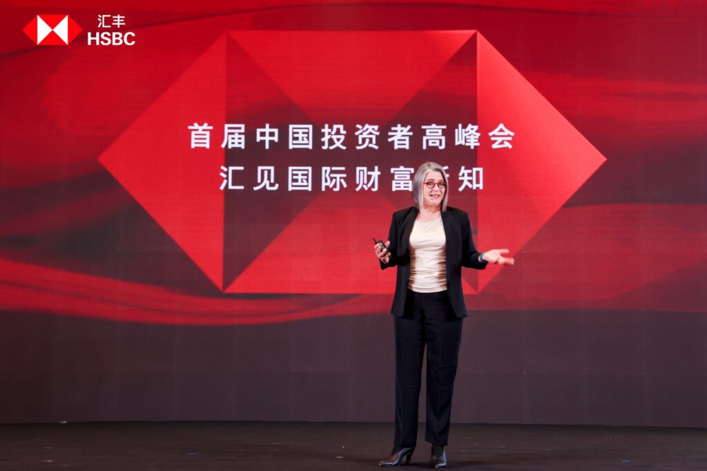 Woman on stage with Chinese characters in background