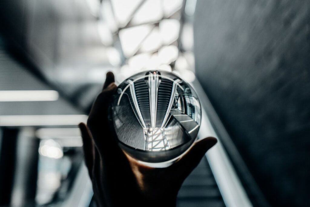 hand holding crystal ball at foot of escalator