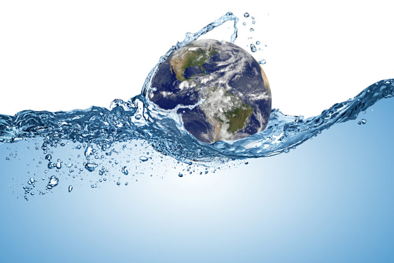Earth floating on and being splashed by a wave