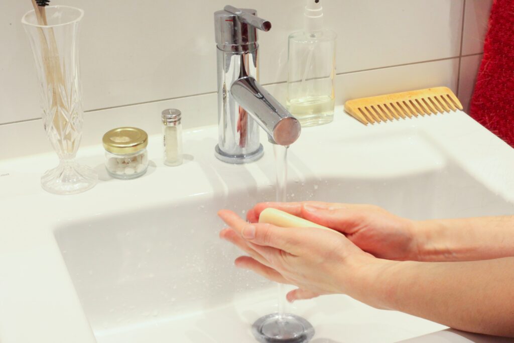 hands washing with soap under faucet